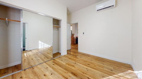 A room with wooden floors and a sliding glass door.