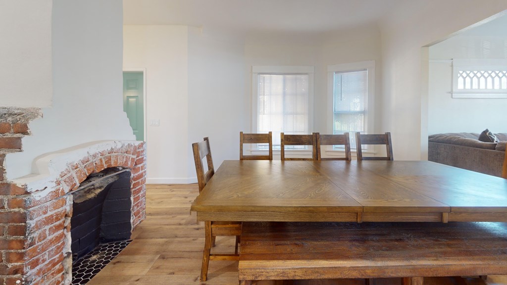 A room with a fireplace and a wooden table.
