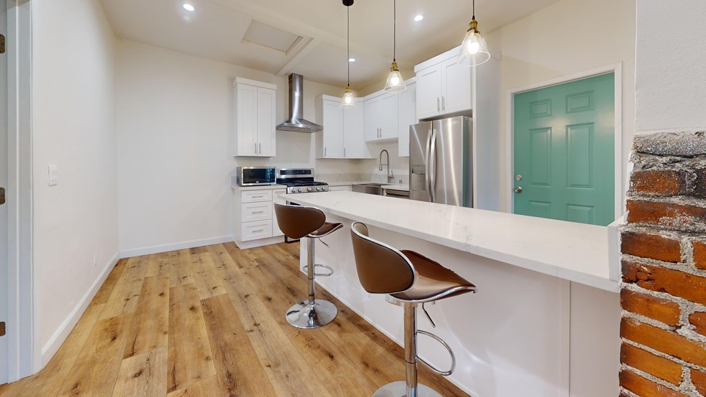 A kitchen with a white counter and a blue door.