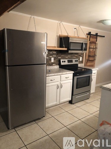A kitchen with a refrigerator, microwave, oven, and stove.