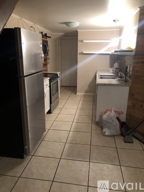A kitchen with a refrigerator, oven, and sink.