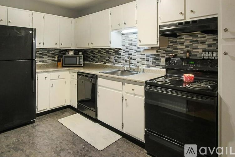 A kitchen with black appliances and white cabinets.