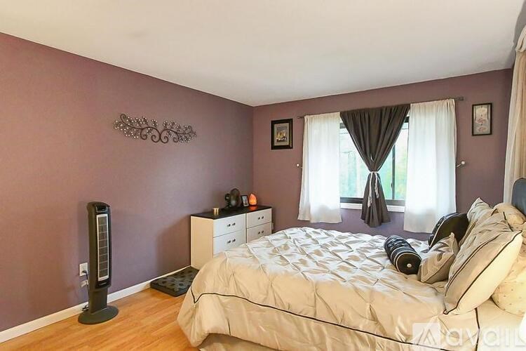 A bedroom with a bed, nightstand, and window.