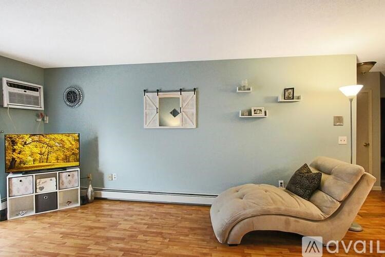 A living room with a couch, television, and a wall hanging.