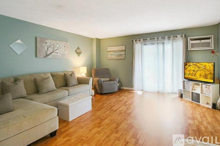 A living room with a couch, chair, and a painting on the wall.