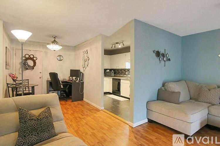 A living room with a grey couch and a blue wall.