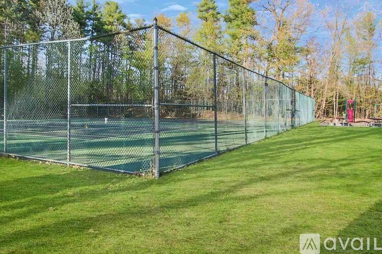 A tennis court is enclosed by a chain link fence.