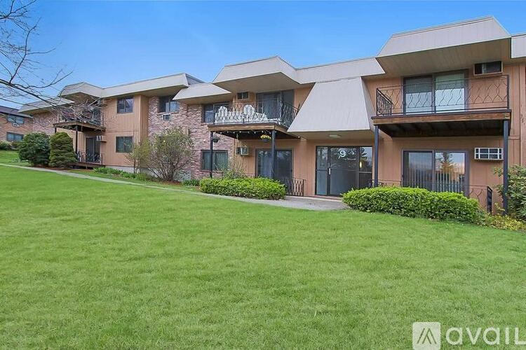 A row of modern townhouses with green lawns in front.