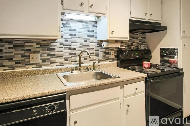 A kitchen with a black stove top oven and a black dishwasher.