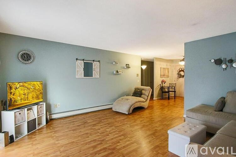 A living room with a wooden floor and a grey wall.