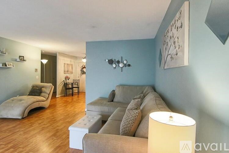 A living room with a grey couch and a lamp.