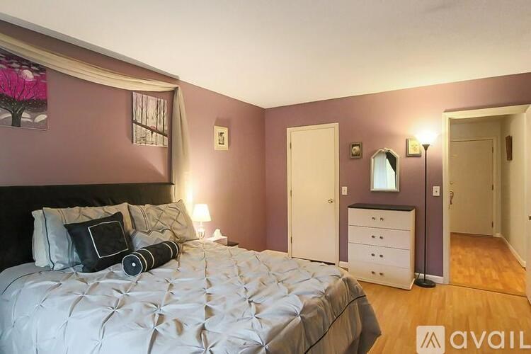 A bedroom with a large bed and a dresser.