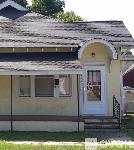 A small house with a white door and a window with a white frame.