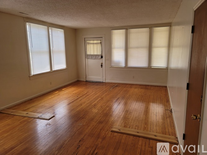 A room with wooden flooring and a door with a window above it.