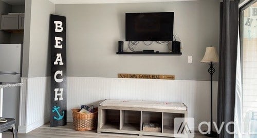 A living room with a sign that says "BEACH" on the wall.