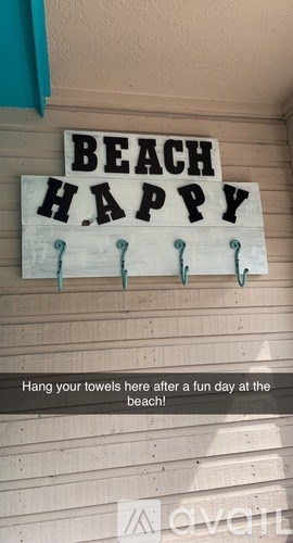 A sign that says "BEACH HAPPY" with a note below it.
