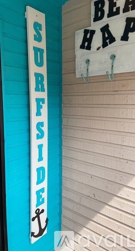 A surfside sign is on a blue wall.
