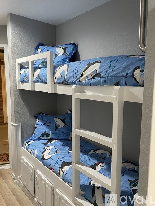 A bunk bed with a blue and white patterned comforter.