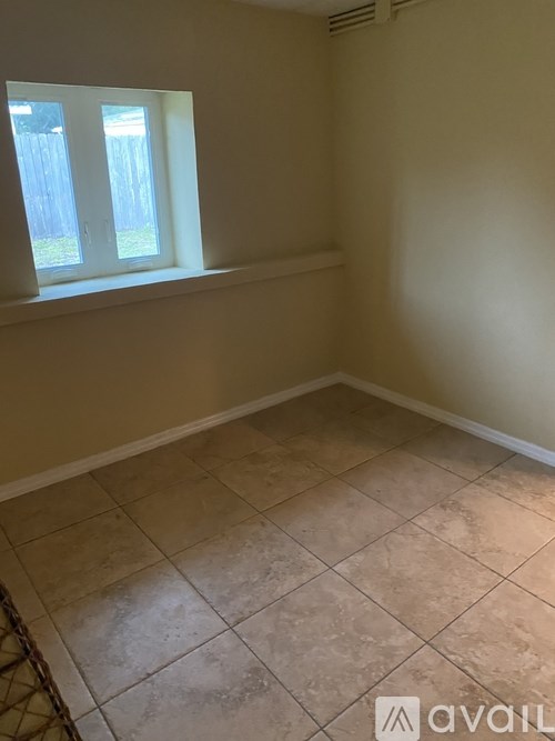 A room with tiled flooring and a window.