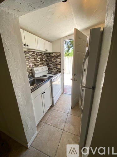 A kitchen with a white stove and cabinets.