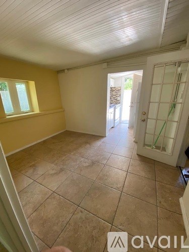 A room with yellow walls and a tiled floor.