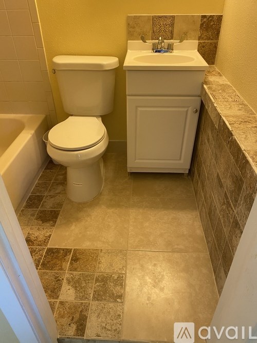 A white toilet and sink in a bathroom.