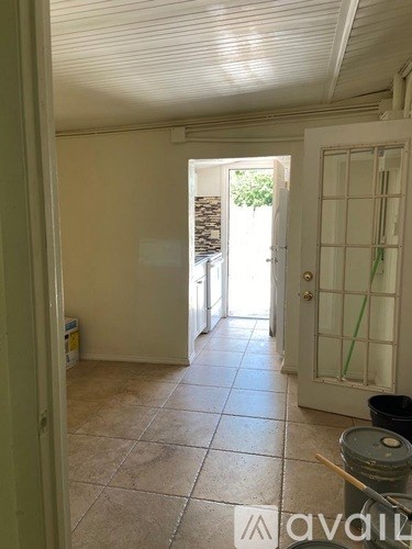 A room with a tiled floor and a door leading outside.