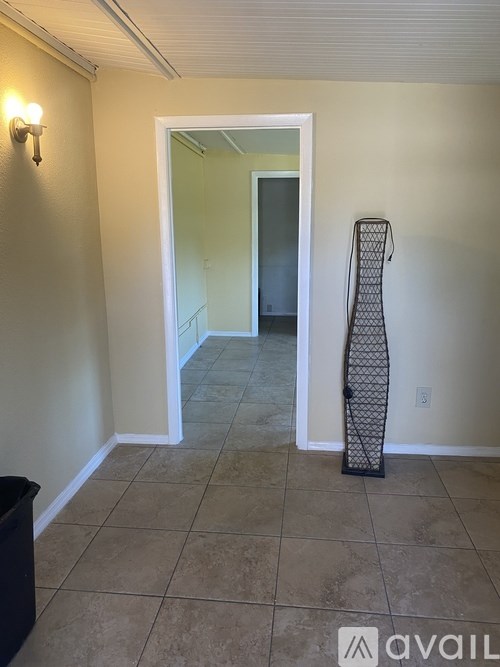 A room with a doorway leading to another room and a black object on the floor.