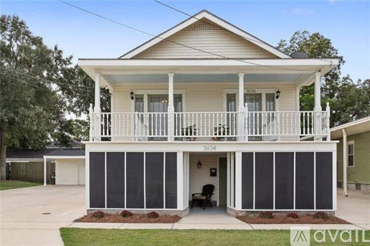 A two-story house with a balcony and a covered entrance.