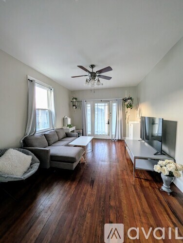A living room with a grey couch and a wooden floor.