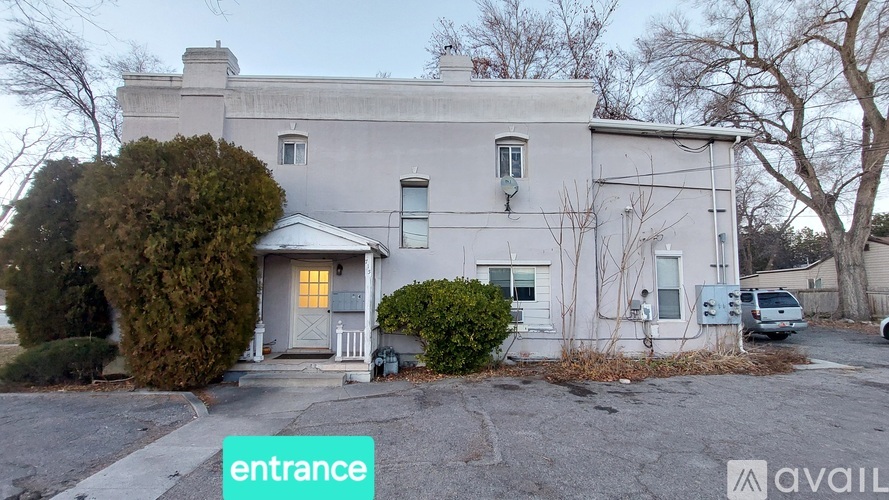 A house with a grey facade and a white door is shown.