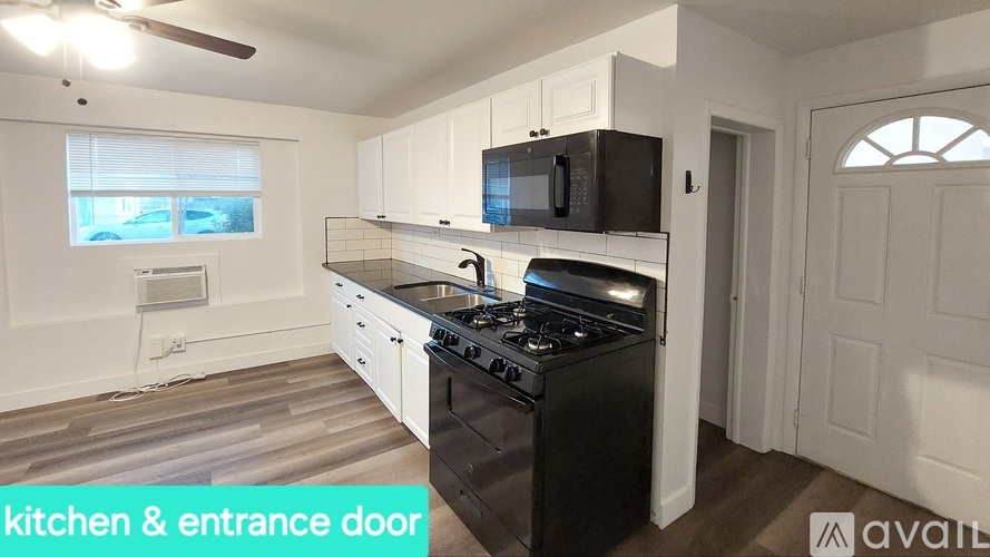 A kitchen with a black stove top oven and a black microwave above the stove.