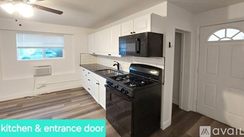A kitchen with a black stove top oven and a black microwave above the stove.