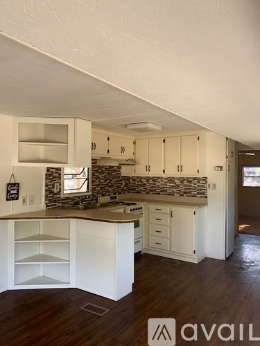 A kitchen with white cabinets and a stone backsplash.
