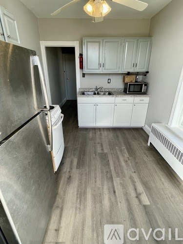 A kitchen with a refrigerator, microwave, and oven.
