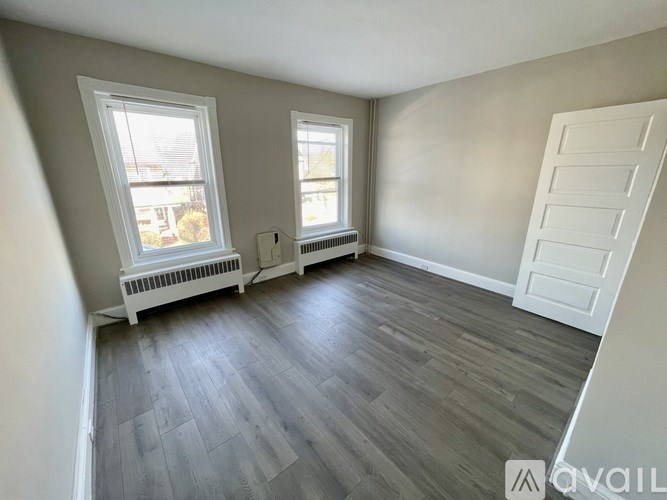 A room with a wooden floor and a white door.