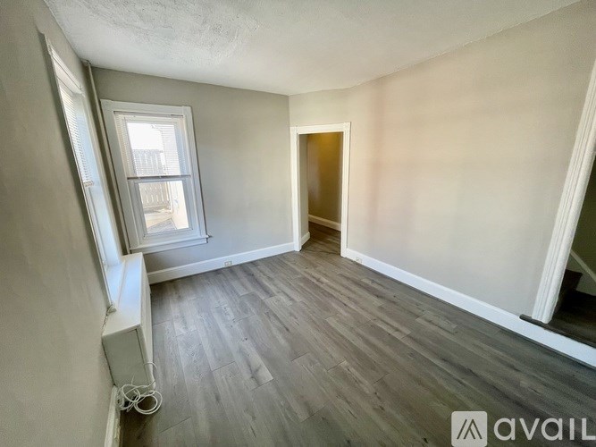 A room with a window and a door is available for rent.