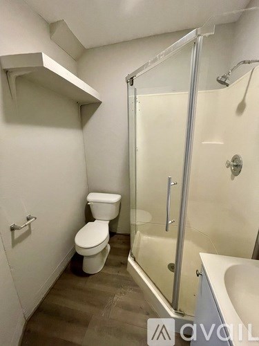 A bathroom with a toilet, sink, and shower.