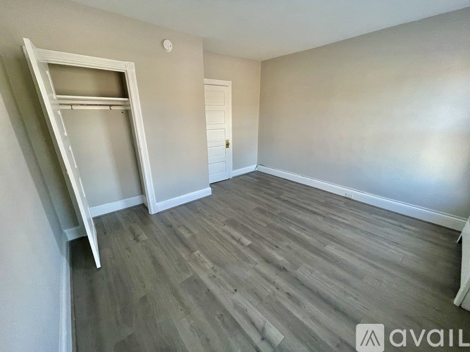 A room with a wooden floor and a white door.