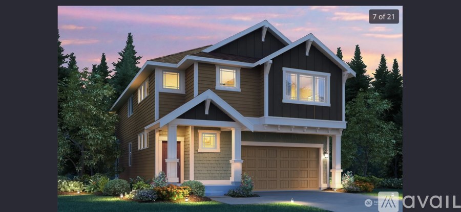 A modern house with a brown and white exterior is shown.