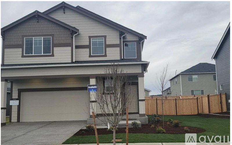 A two-story house with a garage and a driveway.