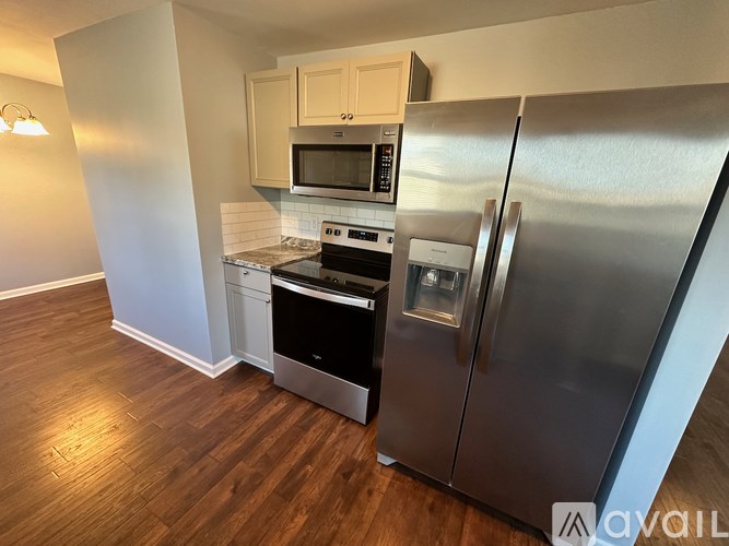 A kitchen with a stainless steel refrigerator, microwave, oven, and stove.