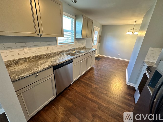 A kitchen with wooden floors and a granite countertop.