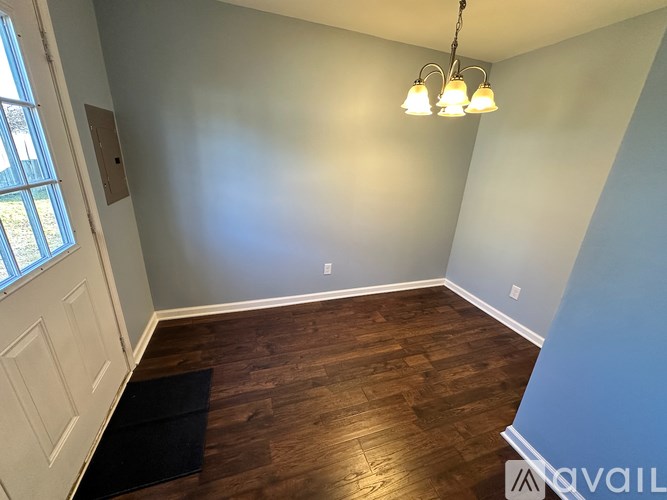 A room with a wooden floor and a chandelier.