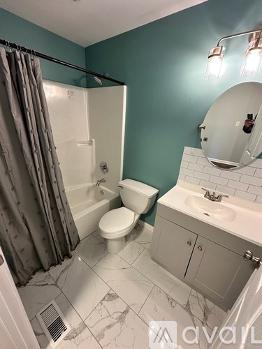 A bathroom with a toilet, sink, and shower.