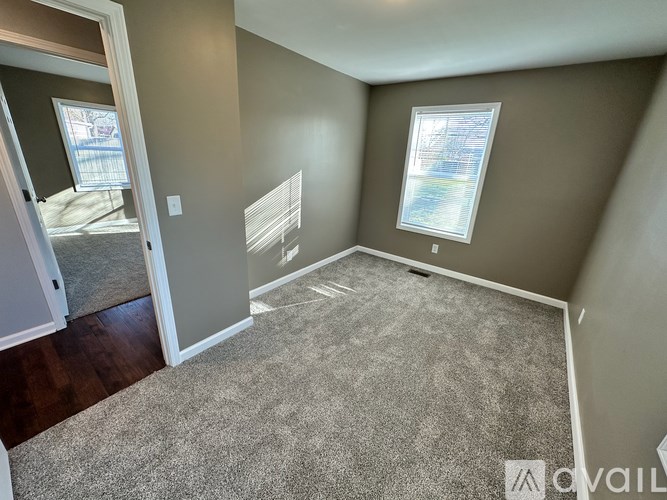 A room with a carpeted floor and a window.