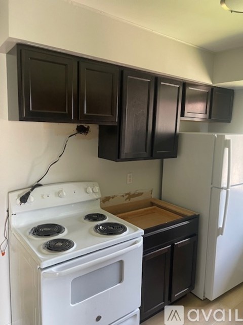 A white stove is in a kitchen with black cabinets.