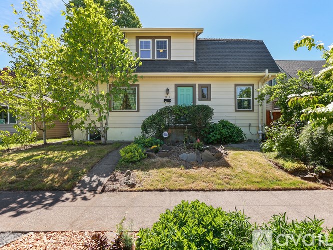A house with a green door and a small garden in front.