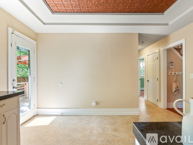A room with a beige wall and a tiled ceiling.