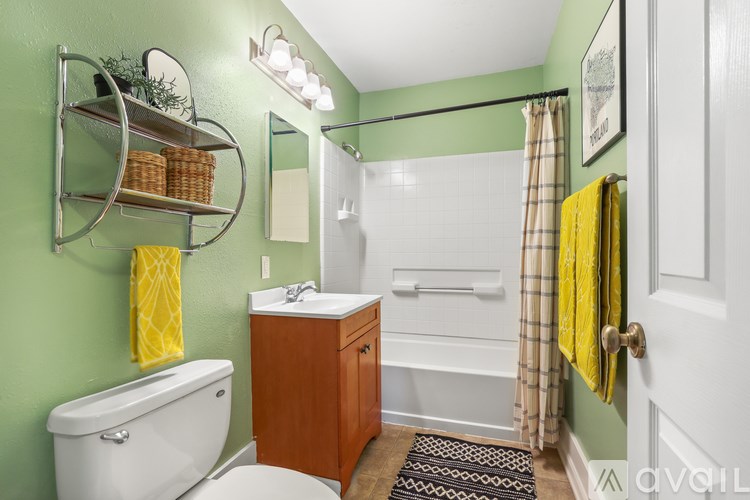 A bathroom with green walls and a white bathtub.